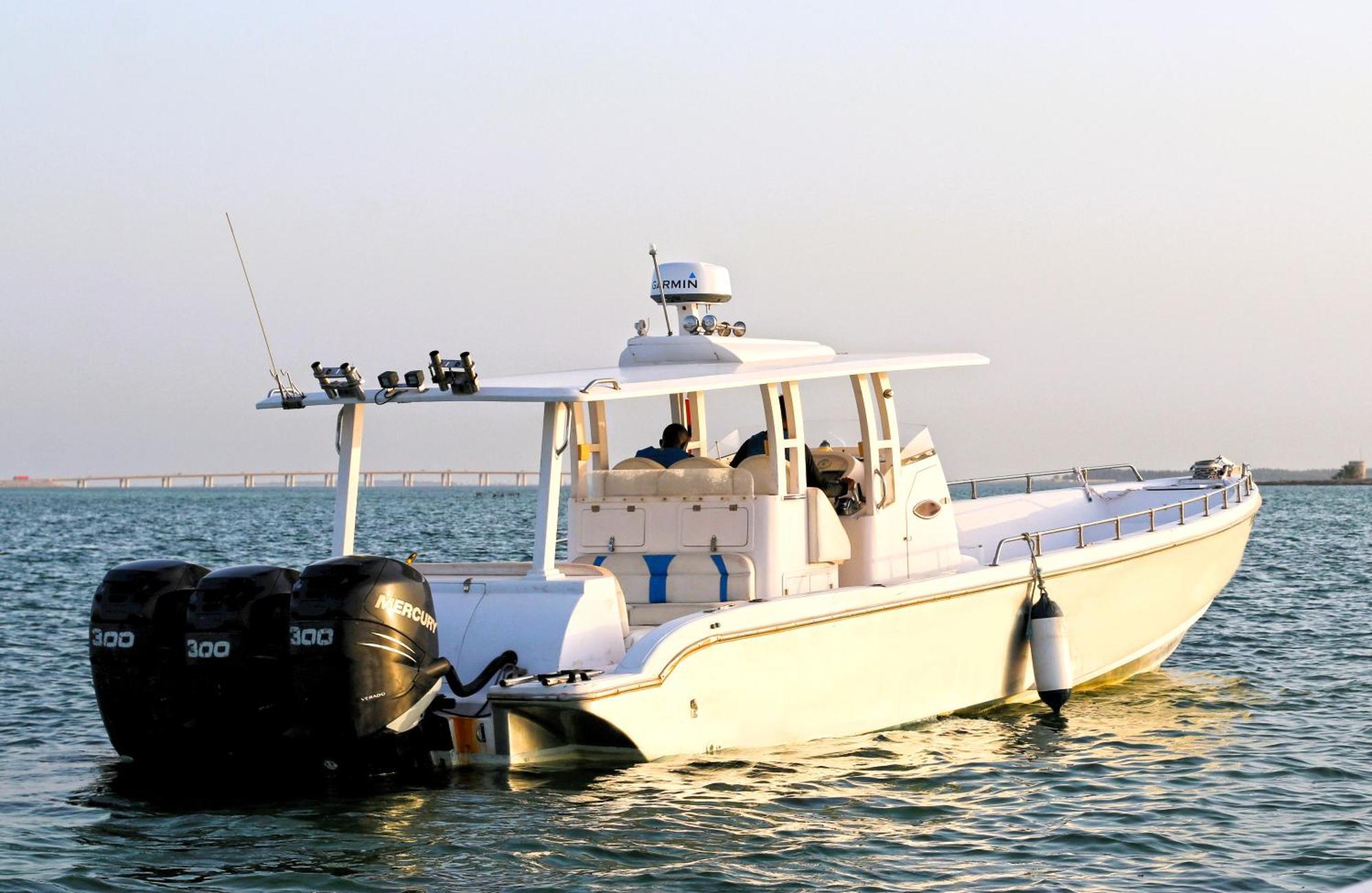 ลากูนา บีช ลักซัวรี รีสอร์ต แอนด์ สปา Hotel มานามา ภายนอก รูปภาพ The photo shows a large, white motorboat equipped with three powerful outboard engines at the stern. The boat has a sleek design, with a spacious open deck and a covered cabin area that likely provides shelter and controls for navigation. The scene i