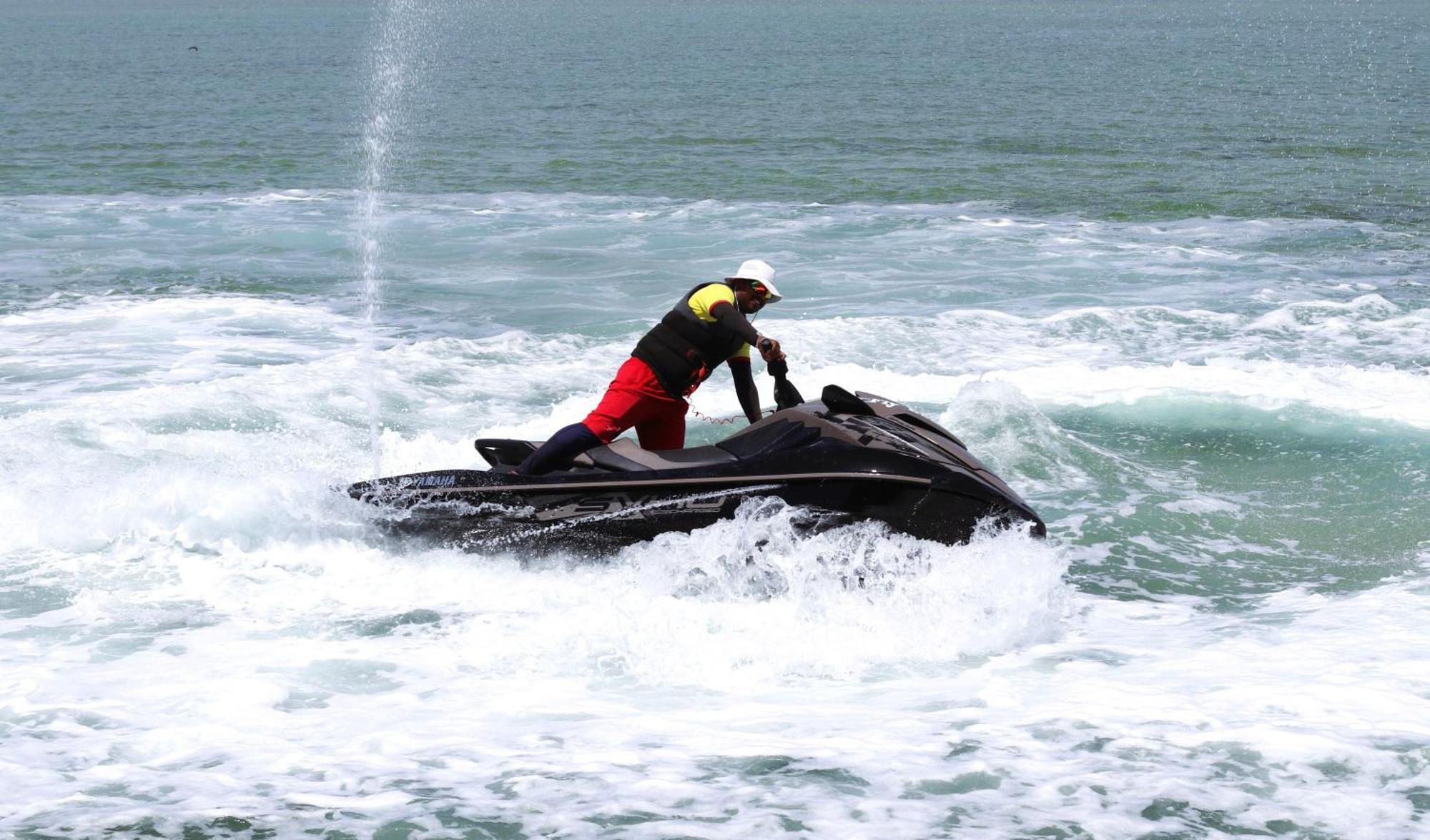 ลากูนา บีช ลักซัวรี รีสอร์ต แอนด์ สปา Hotel มานามา ภายนอก รูปภาพ The photo shows a person riding a jet ski on the water. The rider is positioned upright, leaning forward with one hand on the handlebars, while the jet ski creates splashes of white foam around it. The water appears choppy, likely due to the motion o
